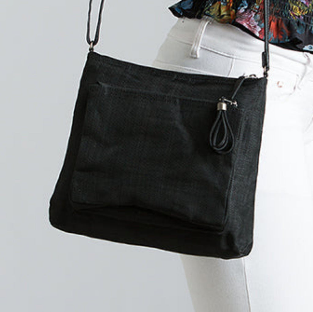 Black Smateria Bustle crossbody bag worn by a person on a light grey background