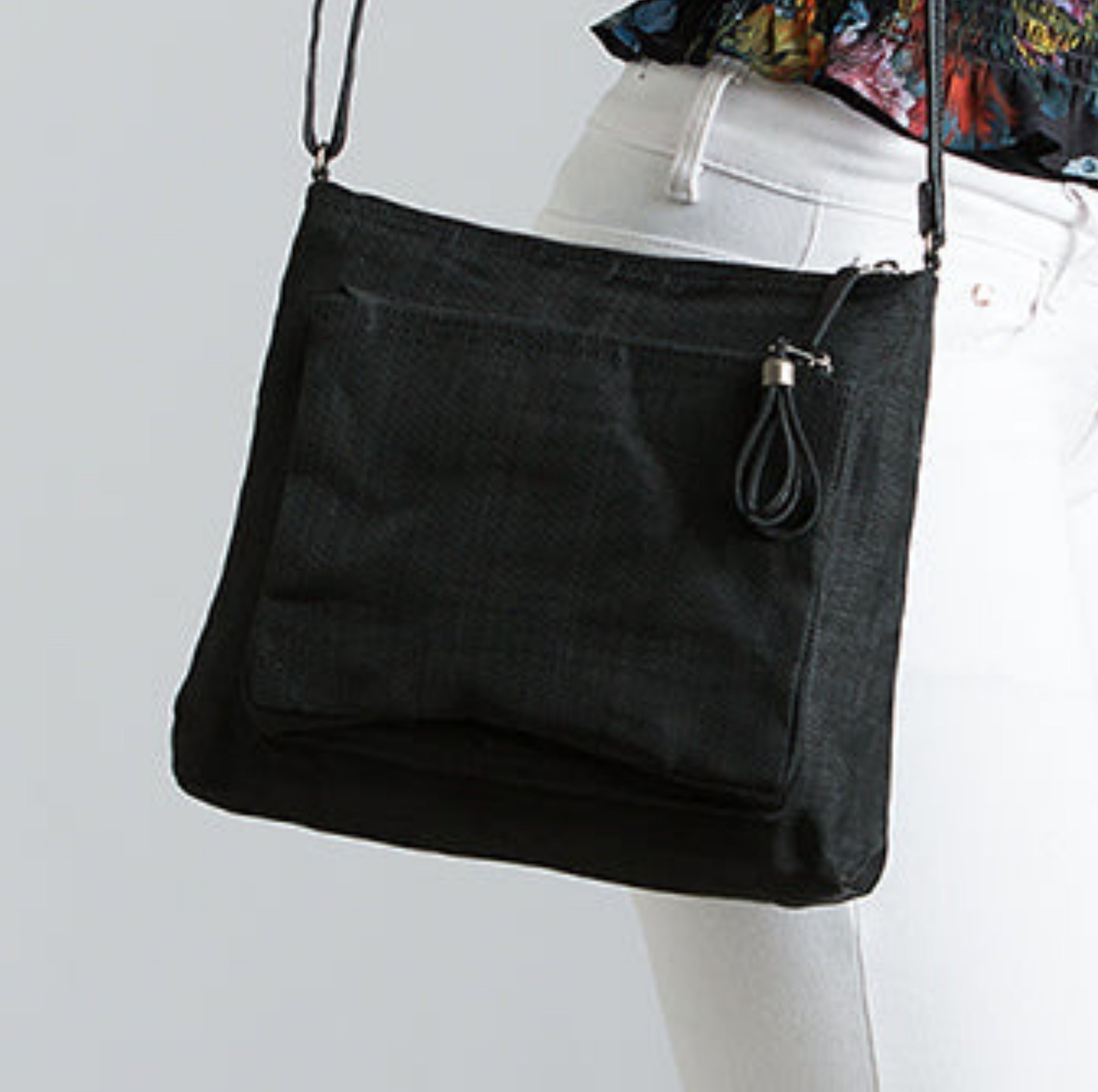 Black Smateria Bustle crossbody bag worn by a person on a light grey background